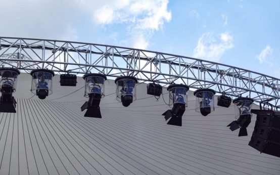 Escenario de concierto en estadio de fútbol con iluminación espectacular para evento masivo
