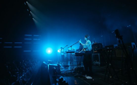 Ambiente de concierto pop en directo con público emocionado bajo luces nocturnas