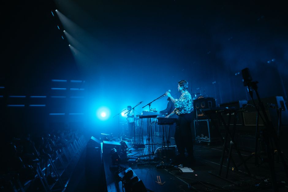 Ambiente de concierto pop en directo con público emocionado bajo luces nocturnas