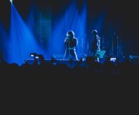 Escenario de rock iluminado con focos intensos durante un concierto en directo