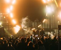 Ambiente de concierto nocturno en estadio con luces escénicas y multitud