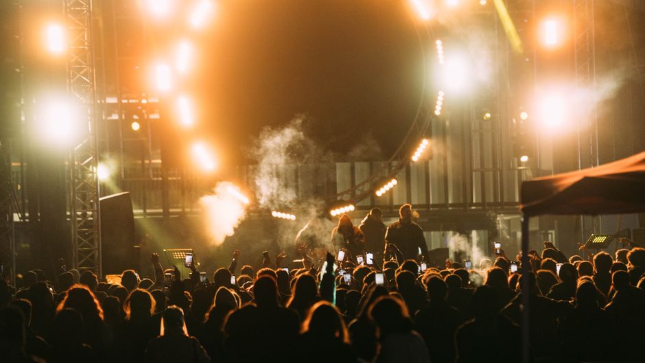 Ambiente de concierto nocturno en estadio con luces escénicas y multitud