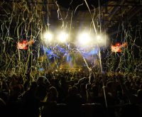 Escenario de concierto pop con luces de colores y ambiente festivo