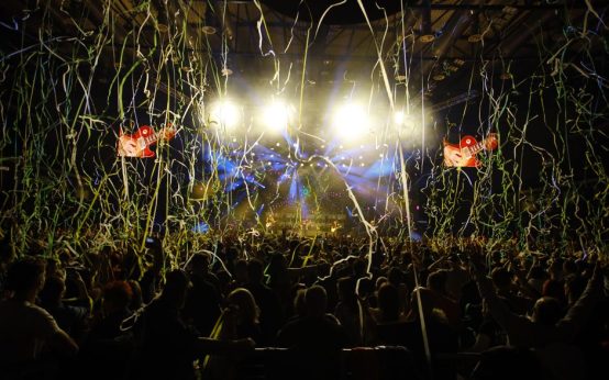 Escenario de concierto pop con luces de colores y ambiente festivo