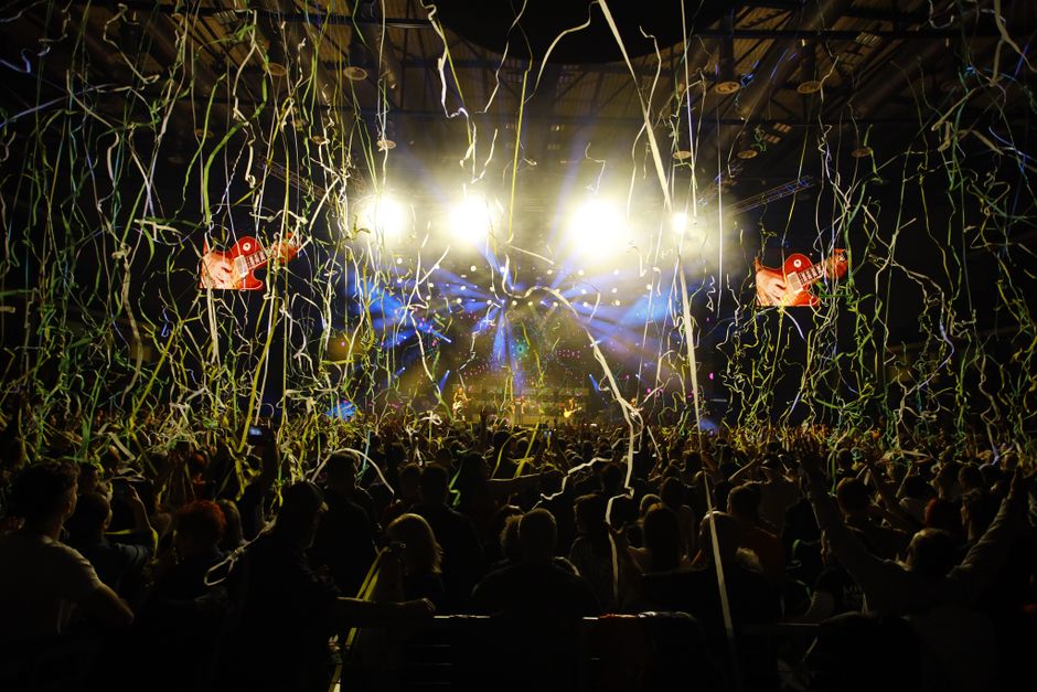 Escenario de concierto pop con luces de colores y ambiente festivo