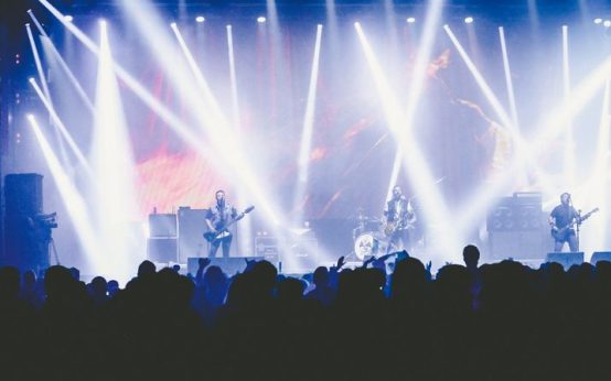 Atmósfera de concierto de música industrial con luces oscuras y neblina escénica