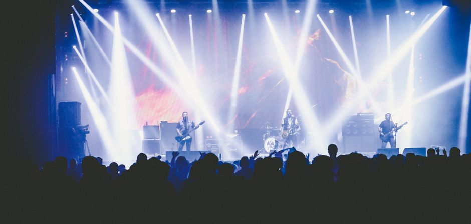 Atmósfera de concierto de música industrial con luces oscuras y neblina escénica