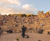 Ambiente nocturno de festival de música al aire libre con escenario iluminado y público