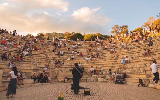 Ambiente nocturno de festival de música al aire libre con escenario iluminado y público