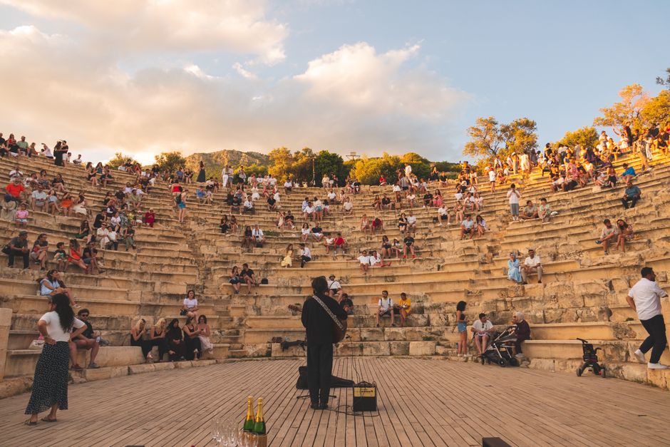 Ambiente nocturno de festival de música al aire libre con escenario iluminado y público