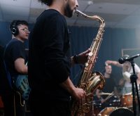 Atmósfera de colaboración musical latina en estudio, ambiente creativo contemporáneo
