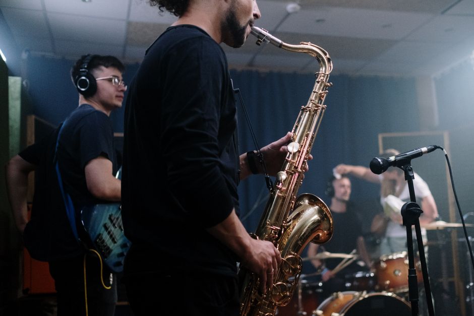 Atmósfera de colaboración musical latina en estudio, ambiente creativo contemporáneo