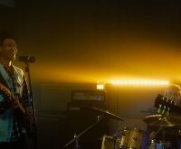 Escenario de concierto pop con atmósfera íntima y luces suaves