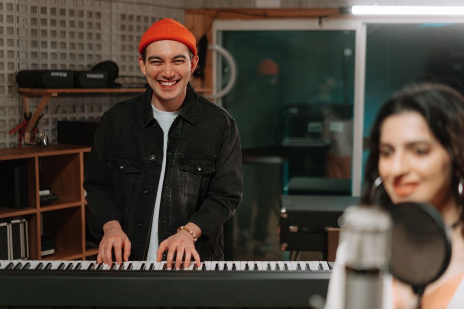 Atmósfera de estudio de grabación de rap con producción instrumental orgánica y piano