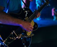 Concierto de rock británico con atmósfera vintage y energía de los años sesenta