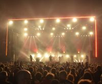 Atmósfera de concierto de rock con iluminación potente y escenario