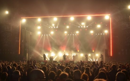 Atmósfera de concierto de rock con iluminación potente y escenario