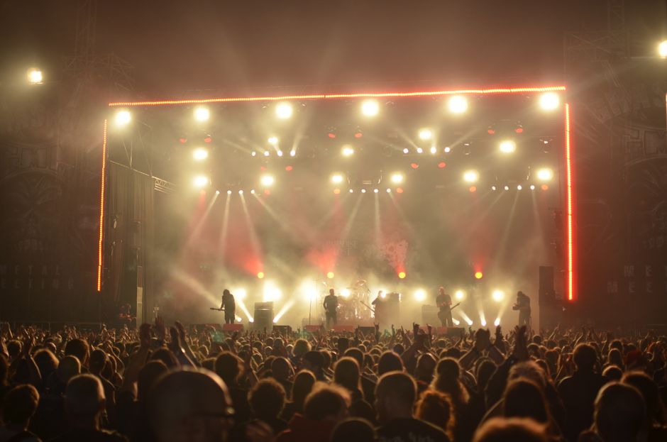 Atmósfera de concierto de rock con iluminación potente y escenario