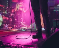 Atmósfera de concierto de rock clásico con luces de escenario, evocando la energía de las presentaciones en vivo