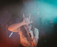 Escenario de concierto indie con focos y público, atmósfera festivalera nocturna