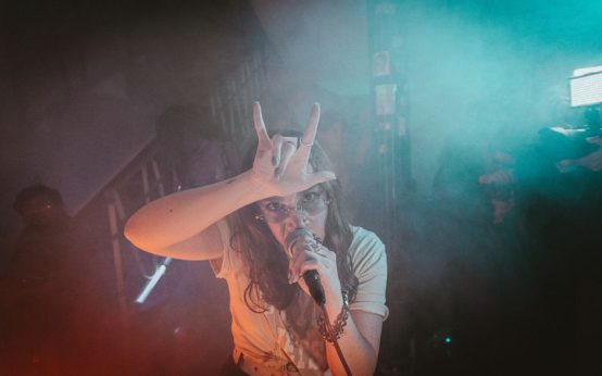 Escenario de concierto indie con focos y público, atmósfera festivalera nocturna