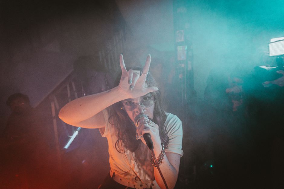 Escenario de concierto indie con focos y público, atmósfera festivalera nocturna