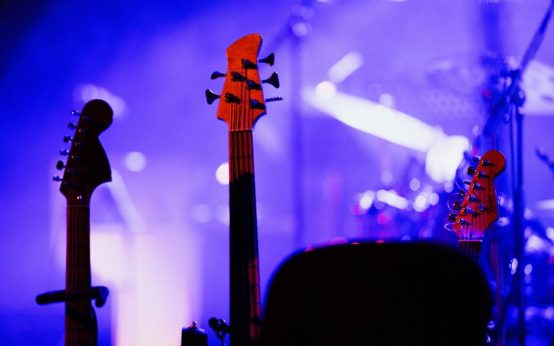 Escenario de concierto de rock con guitarras eléctricas e iluminación intensa, atmósfera blues-rock