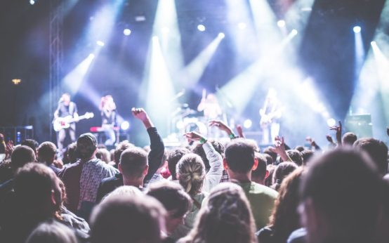 Escenario de concierto de rock con iluminación intensa y ambiente multitudinario