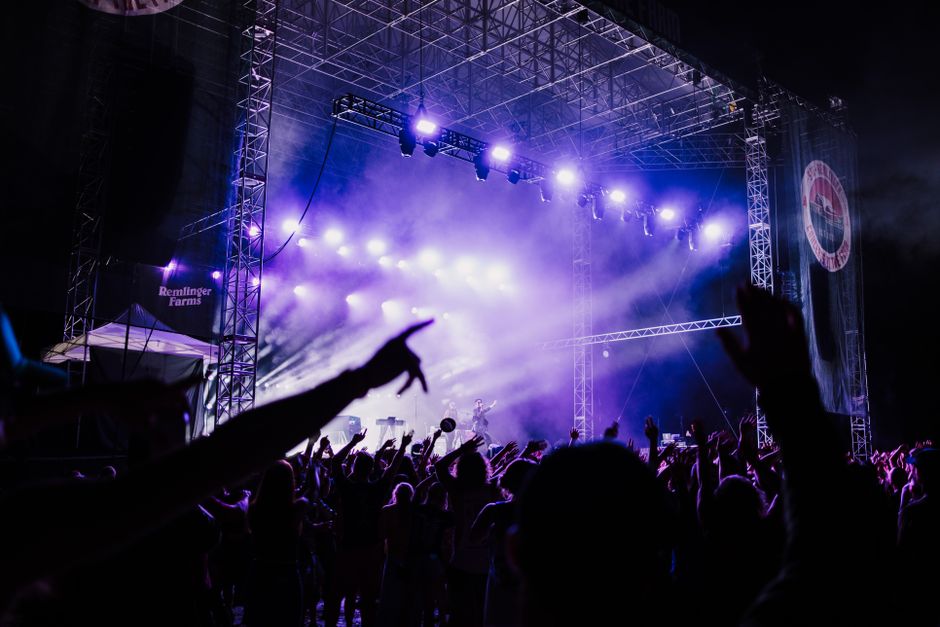 Escenario de concierto de rock con luces intensas y atmósfera energética en directo