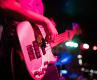 Escenario de concierto pop con luces coloridas evocando la estética musical de los años noventa
