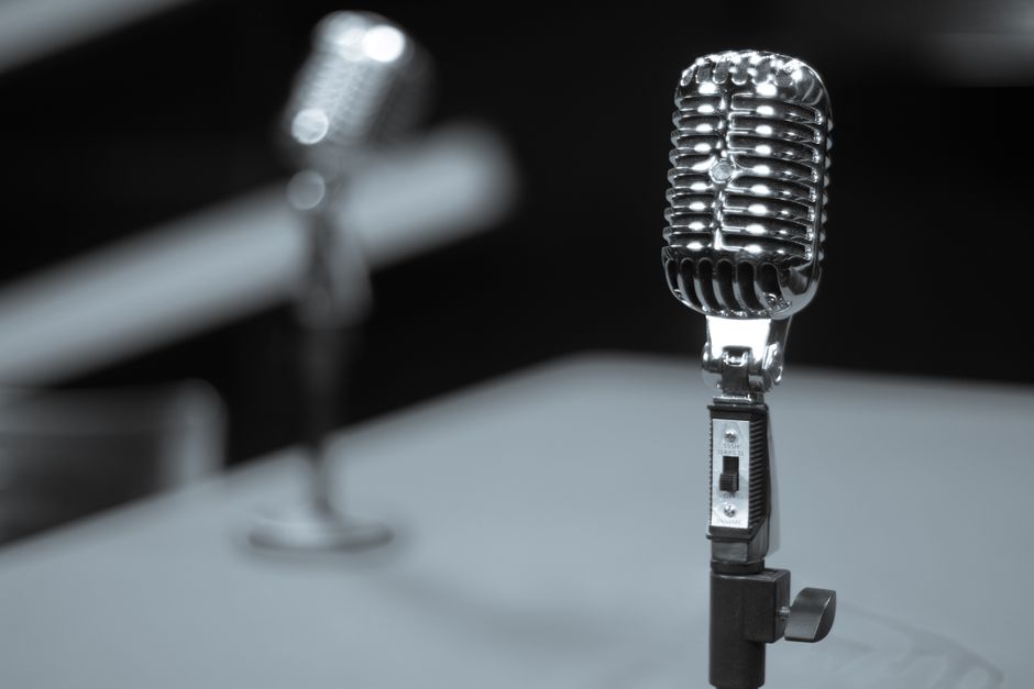 Micrófono clásico en estudio de grabación con iluminación cálida evocando la época dorada de la música española
