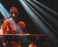 Atmósfera de concierto pop con luces de escenario y energía vibrante
