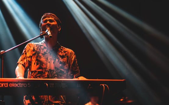 Atmósfera de concierto pop con luces de escenario y energía vibrante