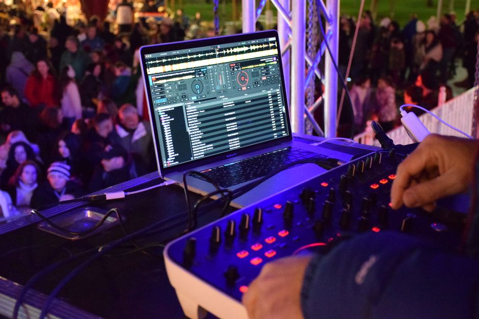 Ambiente de festival de música electrónica con luces y equipo de DJ