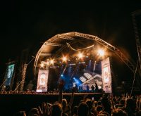Atmósfera intensa de un concierto de nu-metal con iluminación dinámica y público entregado