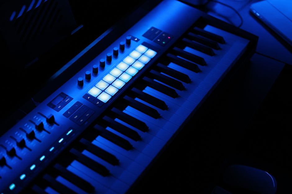 Atmósfera de concierto electrónico con luces oscuras y sintetizadores, evocando la estética darkwave