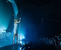 Escenario de concierto pop con micrófono y luces cálidas