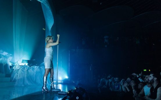 Escenario de concierto pop con micrófono y luces cálidas