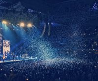 Ambiente de concierto pop con luces de escenario y público