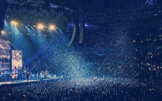 Ambiente de concierto pop con luces de escenario y público