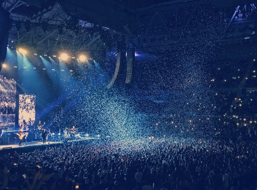 Ambiente de concierto pop con luces de escenario y público