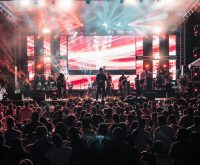 Escenario de concierto latino con luces brillantes y público vibrante