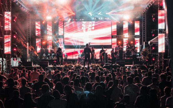 Escenario de concierto latino con luces brillantes y público vibrante