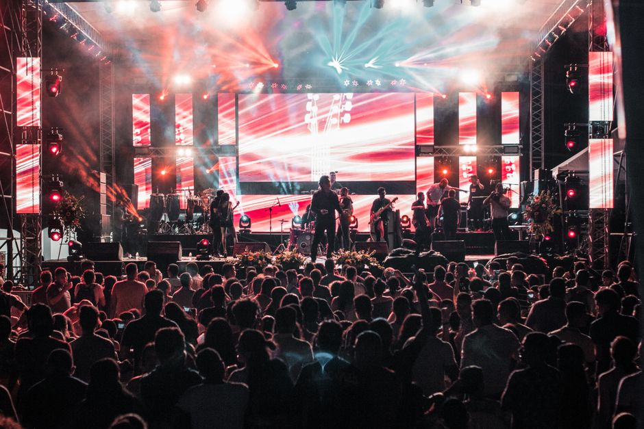 Escenario de concierto latino con luces brillantes y público vibrante
