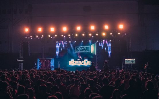 Atmósfera de celebración en un concierto con escenario iluminado y público festivo