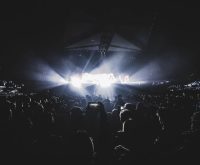 Escenario de estadio con luces nocturnas durante un gran evento musical en vivo