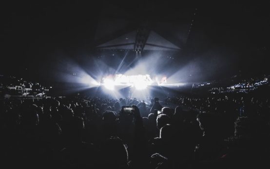 Escenario de estadio con luces nocturnas durante un gran evento musical en vivo