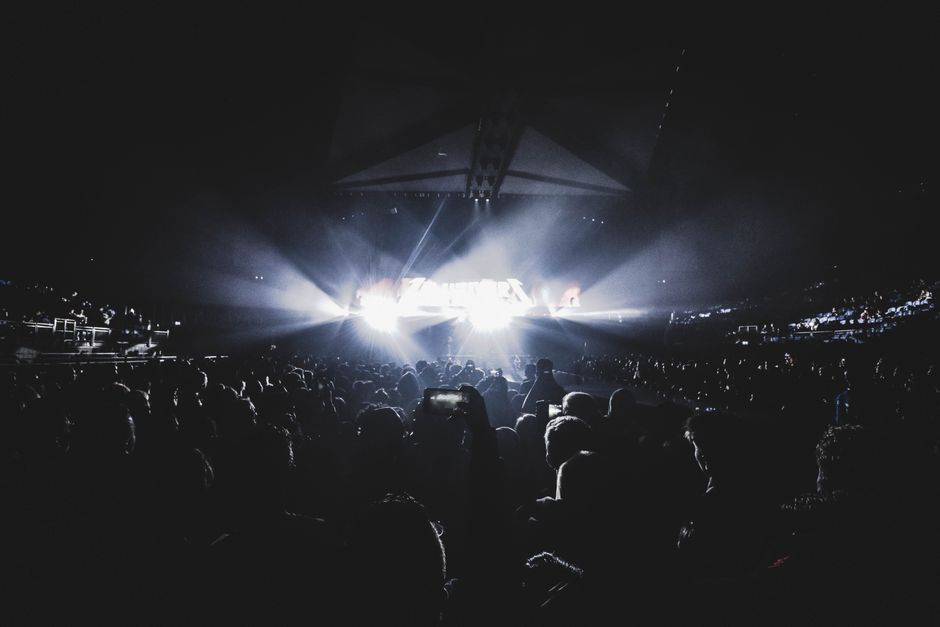 Escenario de estadio con luces nocturnas durante un gran evento musical en vivo