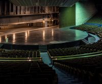 Imagen ilustrativa. Escenario de arena musical con iluminación profesional.