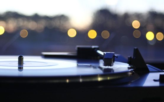 Disco de vinilo sobre tocadiscos evocando la época dorada del pop de los años 70